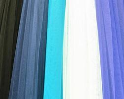 Detailed close up view on samples of cloth and fabrics in different colors found at a fabrics market photo