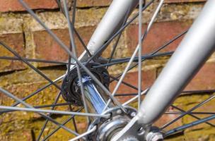 Close up view at a bicycle wheel with several metal spokes photo
