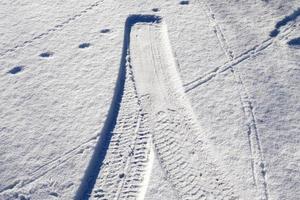 Tire Tracks on snow covered streets in a close up view. photo