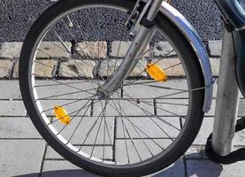 Close up view at a bicycle wheel with several metal spokes photo