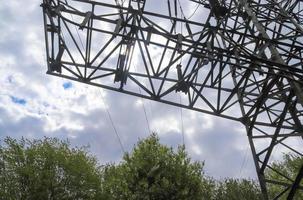 Close up view on a big power pylon transporting electricity in a countryside area photo