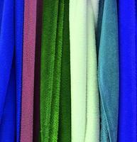Detailed close up view on samples of cloth and fabrics in different colors found at a fabrics market photo