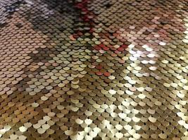 Close up view on samples of sequin fabric in golden colors photo
