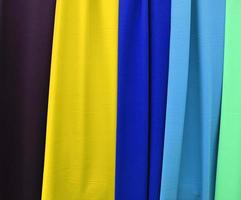 Detailed close up view on samples of cloth and fabrics in different colors found at a fabrics market photo