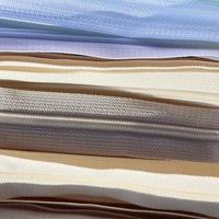 Detailed close up view on samples of cloth and fabrics in different colors found at a fabrics market photo