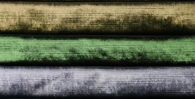 Detailed close up view on samples of cloth and fabrics in different colors found at a fabrics market photo