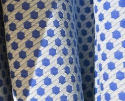 Detailed close up view on samples of cloth and fabrics in different colors found at a fabrics market photo
