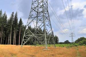 Close up view on a big power pylon transporting electricity in a countryside area photo