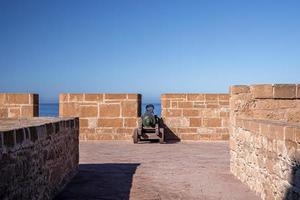 Old cannon aim through slit in wall at historic fortress photo