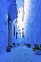 The famous blue colored house with traditional structure on both side of narrow alley photo