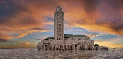 vista de ángulo bajo de la histórica mezquita hasan ii con el minarete más alto contra el cielo dramático foto