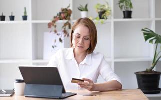 Asian senior woman using a laptop PC with a credit card. photo