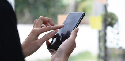 Close up woman holding smartphone, typing message, texting, chatting, female hands using cellphone, browsing mobile apps, internet, checking social networks, email, playing games on phone photo