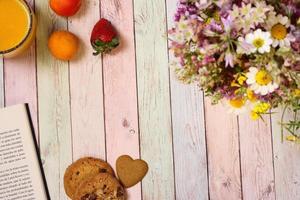 Juice, apricots and book on colorful table, copy space photo