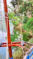 A rope bridge is suspended over a river in Uttarakhand, India. photo