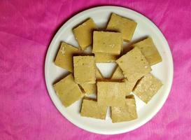 mawa burfi - un delicioso festival indio dulce en un plato blanco sobre un fondo de color. foto