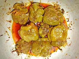 Boiled and spicy potatoes stuffed Shimla Mirch ki Sabzi - stuffed spicy capsicum curry - placed on a silver coloured wok. photo
