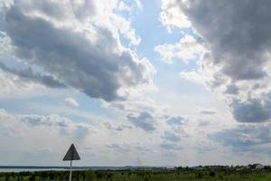 a road with a forest background and a blue sky with clouds. photo