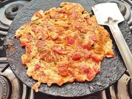 tortilla de tomate preparada cocinando en una sartén de gas foto