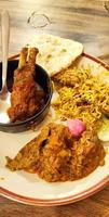 Chicken curry, mutton curry, rice and chapatti in white plate on light backgroung. photo