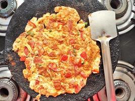Tomato omelette kept ready by cooking on a gas pan photo