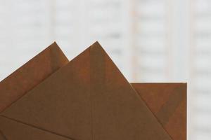 Three closed brown craft envelopers corners on light blurred background, horizontal photo. Recycled paper, mail concept, blank envelopes for card or invitation photo