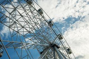 Bottom view of the ferris wheel and the sky with clouds. photo