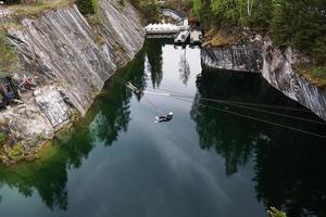 A man jumping from a bungee over a canyon in the Ruskeala mountain park. Karelia photo