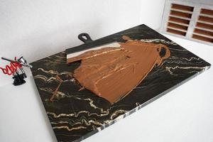 Milk chocolate on a granite board for tempering chocolate. Spatula for chocolate photo