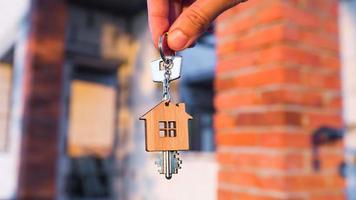 Hand with the key to the future house on the background of a construction site and walls made of porous concrete block. Building a home, moving to a new cottage, farm in the countryside photo