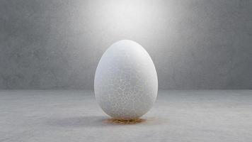 Cracked egg to hatching with light inside, on cement floor, and light shining from above. photo