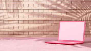 Pink laptop with decoration minimal. Shadow from tree and window on brick wall. photo