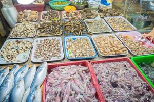 Variety of fresh seafood on market. Fresh salmon, sea bass, red snapper, mackerel, crab, lobster, shrimp, black mussels, oyster, scallop and octopus on ice in market photo