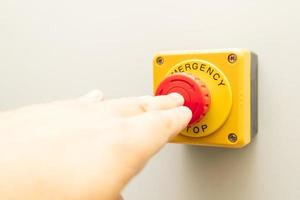 Stop Button and the Hand of Worker About to Press it. emergency stop button. Big Red emergency button or stop button for manual pressing. photo