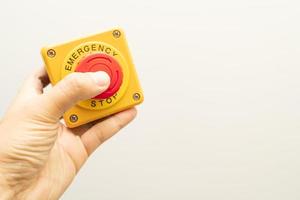 botón de parada y la mano del trabajador a punto de presionarlo. botón de parada de emergencia. gran botón rojo de emergencia o botón de parada para presionar manualmente. foto