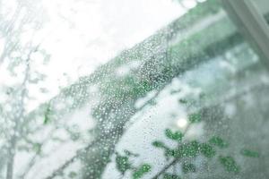 Selective Focus, Water droplets on the glass on a rainy day. rain drops during raining in rainy day outside window glass with blurred background. photo