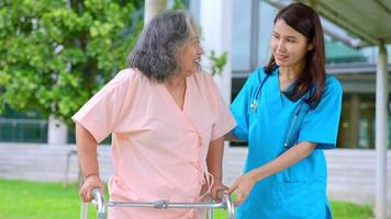 cuidadoso cuidador asiático o enfermera que cuida al paciente asiático anciano en silla de ruedas. concepto de jubilación feliz con el cuidado de un cuidador y ahorros y seguro de salud para personas mayores. cuidado de los ancianos video