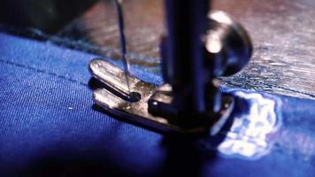 macro shoot of machine needle on the blue fabric, The needle of the sewing machine. video