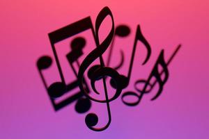 notas musicales y símbolos con curvas y remolinos sobre un fondo rosa. ilustración 3d foto