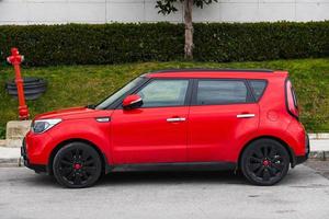 lado turquía 03 de marzo de 2022 el kia soul rojo está estacionado en la calle en un cálido día de otoño con el telón de fondo de un jardín foto