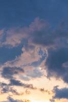 Blue sky background with tiny sunset clouds  in summer season. Cloud texture photo