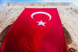 close-up of the Turkish national flag hanging on an ancient stone building photo