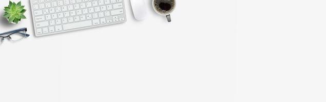 Computer keyboard and mouse from above with coffee and flower on white background. photo