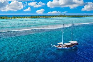 Beautiful turquoise ocean water sailboat, view aerial drone seascape. Tropical sea waves, amazing aerial coral reef, lagoon. People recreational outdoor activity, swimming, snorkeling, diving tourism photo