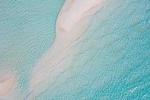 Summer seascape beautiful waves, blue sea water in sunny day. Top view from drone. Sea aerial view, amazing tropical nature background. Beautiful bright sea with waves splashing and beach sand concept photo