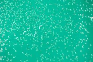 Water drops on glass on green background. Abstract relaxing background pattern photo