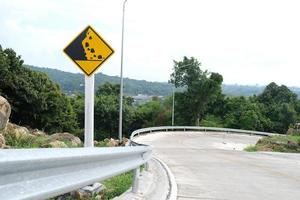 Señal de carretera de caída de piedra de advertencia en carretera de montaña.