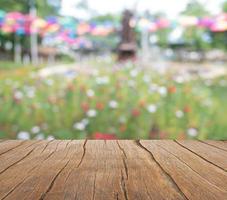 un balcón de madera se extiende hacia un colorido campo de flores foto