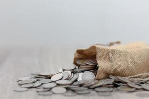 Coins in sack on the wooden table photo