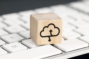 Cloud computing icon on wooden block on computer keyboard photo